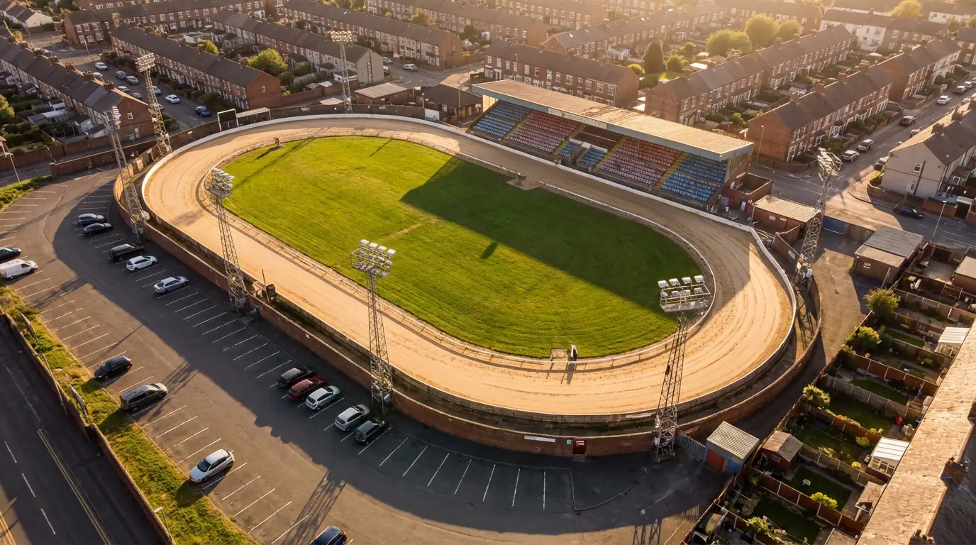 Aerial view of a UK greyhound racing stadium showing the oval sand track and floodlights